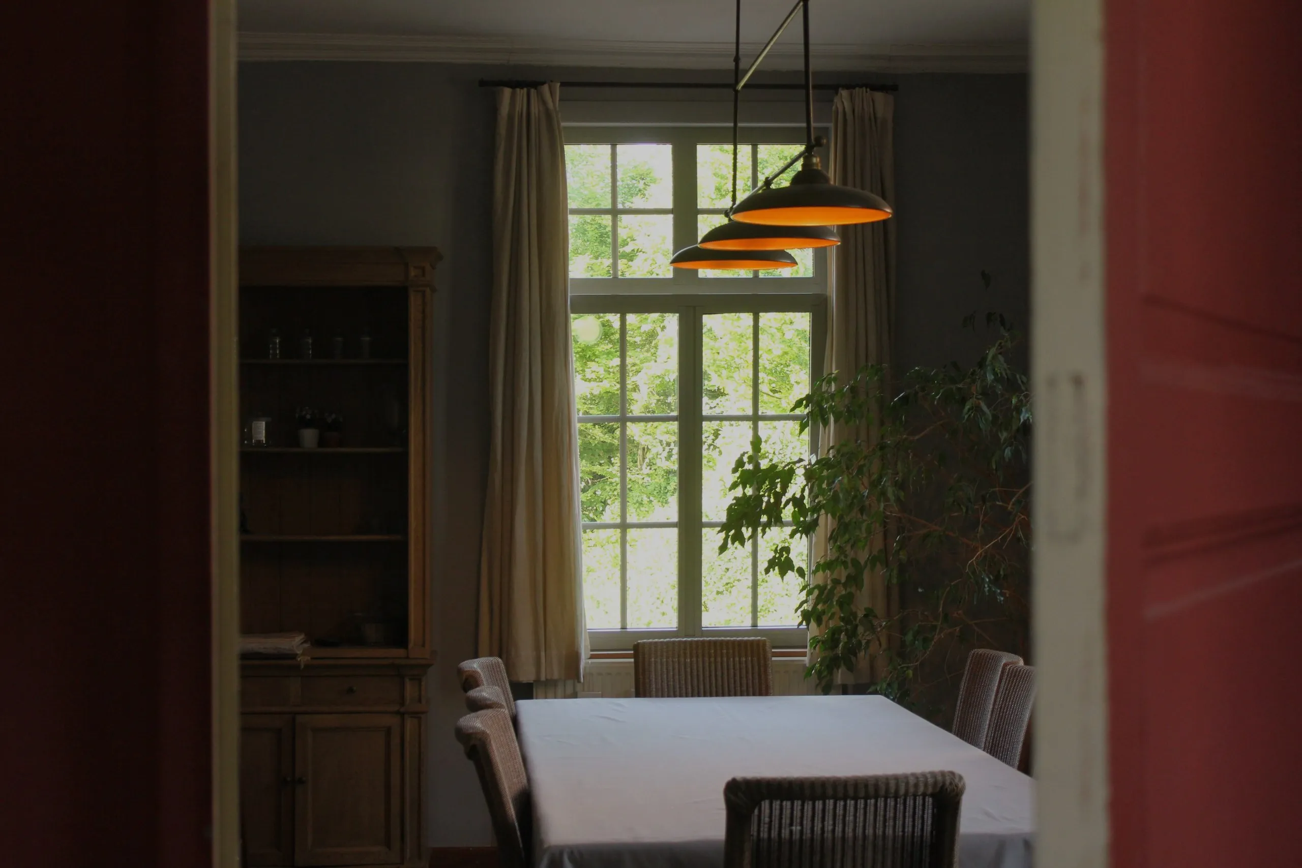 Salle à manger avec longue table et hautes fenêtres