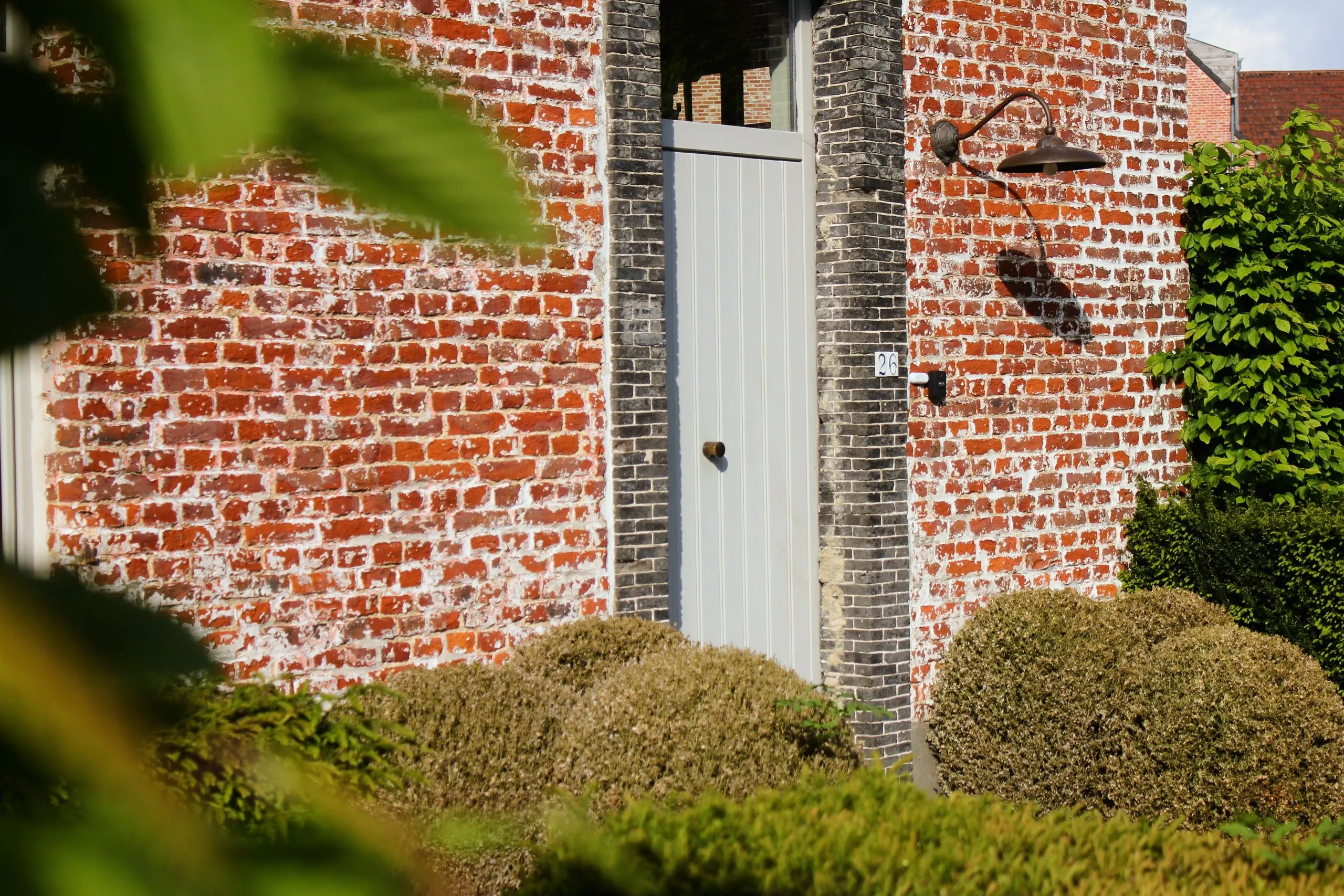 Détail de la façade en briques et de la porte en bois