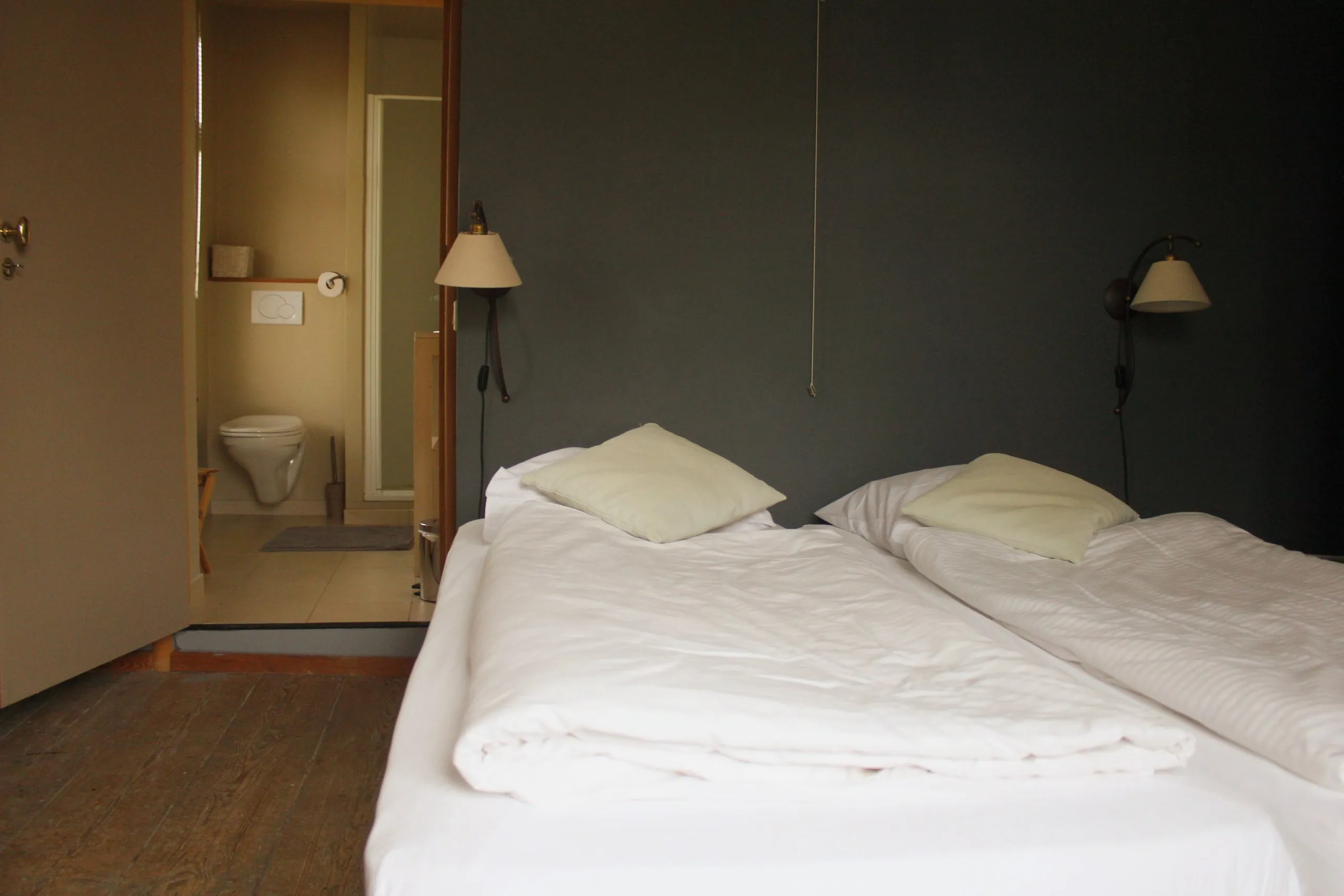 Chambre avec lits faits et salle de bain privative