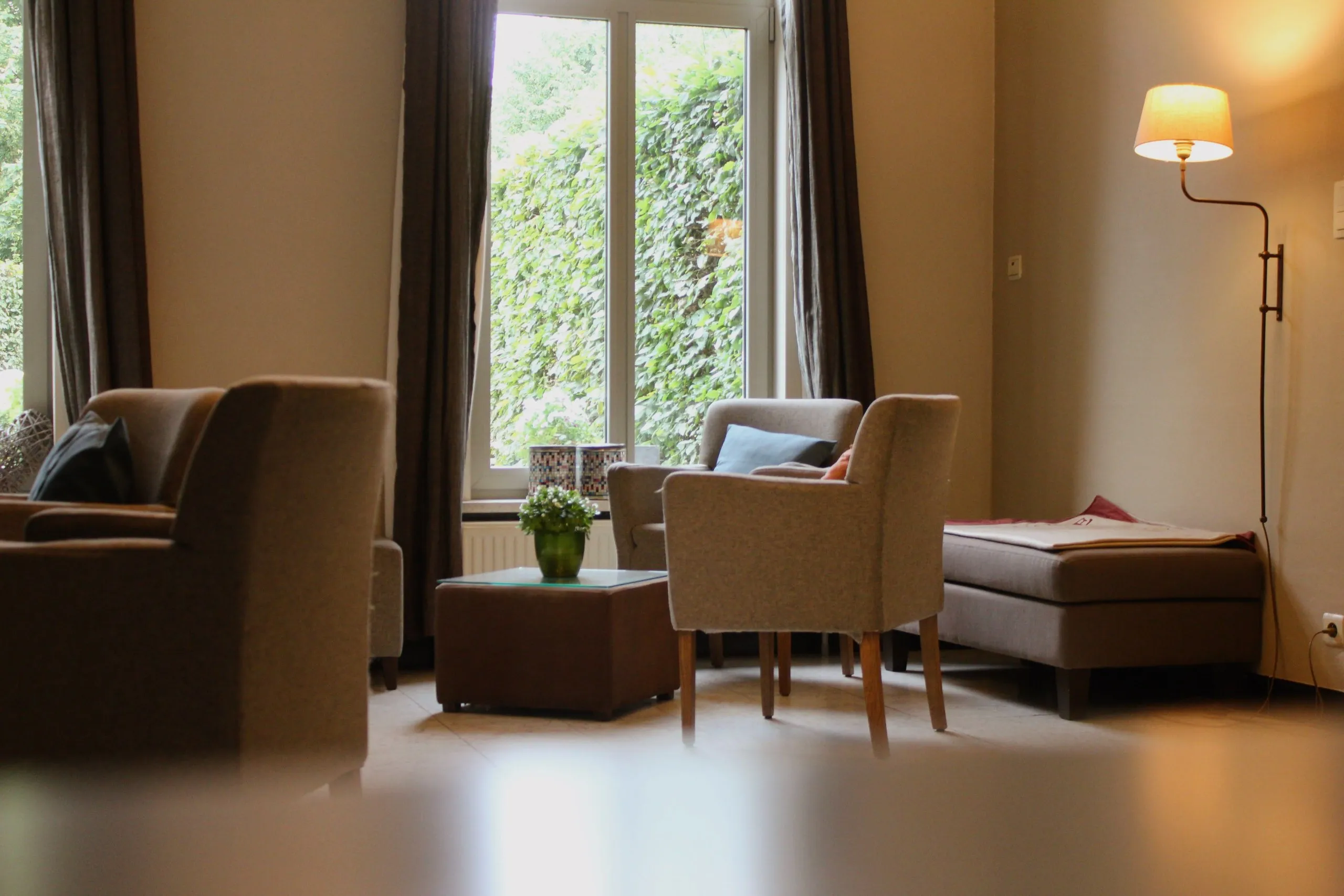 Coin salon lumineux avec fauteuils près de la fenêtre
